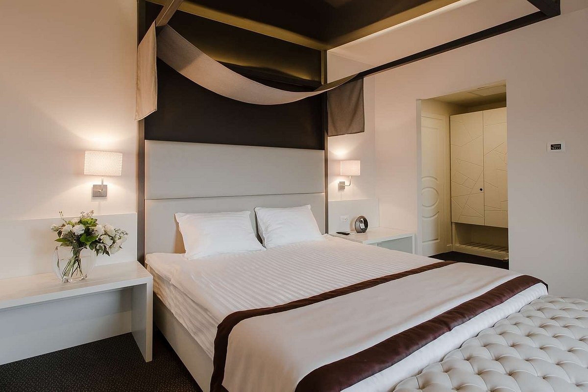 Łóżko z miękkim wezgłowiem w pokoju w UNO Design Hotel Odessa Ukraina